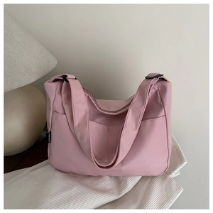Detail view of pink tote bag showing the fabric texture and black woven brand label