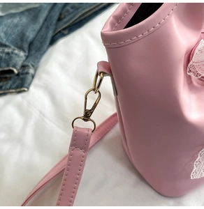 Detailed shot of pink PU leather bag featuring delicate white lace trim and gold metal hardware