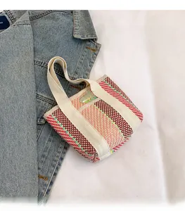 Detail of colorful woven tote bag featuring striped texture and durable canvas handles