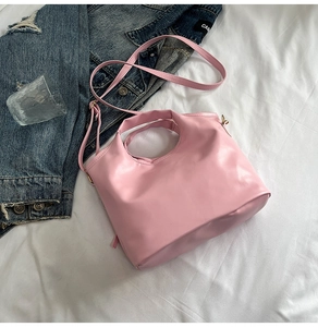 Detailed macro view of pink PU leather bucket bag with round handle and adjustable strap