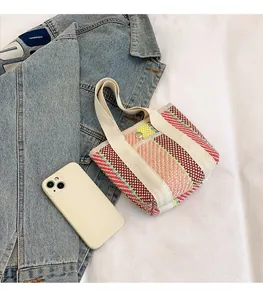 Detailed top view of a mini woven tote bag with colorful stripes and snap button closure