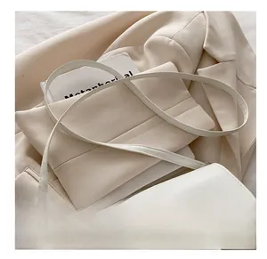 Détail du sac bandoulière en cuir blanc avec boucle argentée et fine bandoulière