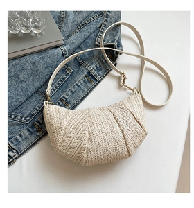 Detail of cream woven shoulder bag with V-shaped texture and golden metal hardware