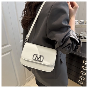 Vue détaillée d'un sac bandoulière en cuir blanc avec logo M argenté sur un mannequin