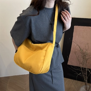 Bright yellow minimalist nylon tote bag shown on a model for a casual summer style