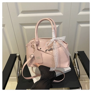 Detail of pink fashion tote bag with delicate white lace bow and adjustable shoulder strap