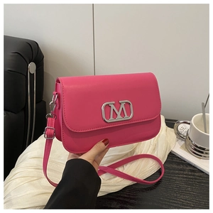 Gros plan d'un sac à bandoulière en cuir rose rouge avec logo M en métal argenté