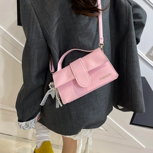 Pink faux leather handbag with gold Fashion text and pearl lace charm detail