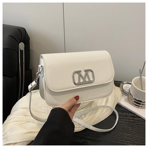 Gros plan d'un sac bandoulière en cuir blanc avec un fermoir en métal argenté en forme de M