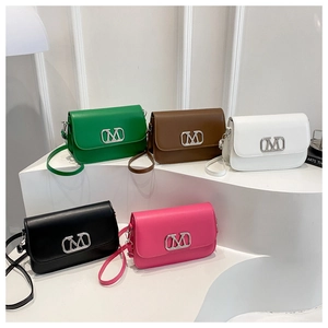 Cinq sacs bandoulière minimalistes colorés avec logos M en métal sur support à étages