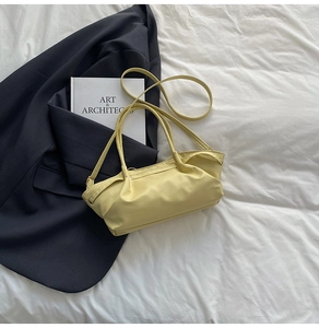 Detail of pale yellow pleated shoulder bag with soft faux leather and slim strap