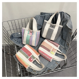Detail of colorful woven tote bags with striped patterns and durable canvas handles