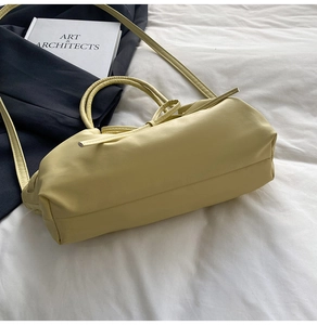 Vue détaillée d'un sac cabas en cuir jaune pâle avec nœud décoratif et poignée ronde