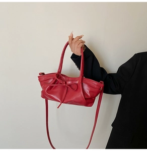 Détail du sac cabas en similicuir rouge avec nœud élégant et design nuage plissé