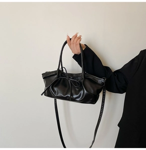 Gros plan du sac fourre-tout noir avec cuir plissé et détail de nœud élégant