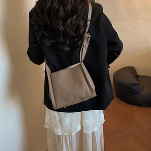 Fashionable dark brown leather bucket bag shown in a stylish indoor lifestyle setting
