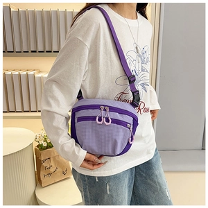 Detail of purple checkered crossbody bag featuring dual zippers and adjustable wide strap