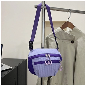 Detail of light purple checkered crossbody bag with multiple zippers and nylon texture