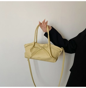 Détail du sac cabas jaune crème avec nœud et design plissé porté à la main