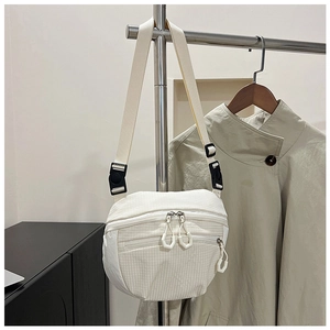 Detail of white checkered crossbody bag with adjustable strap and plastic buckle