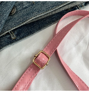 Detailed view of pink PU leather shoulder strap with gold buckle and stitching