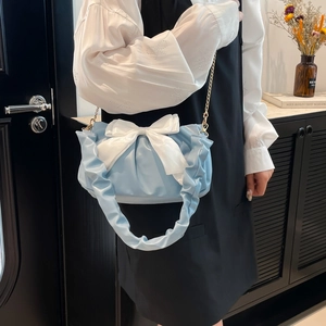 Sac nuage plissé bleu clair avec un grand nœud en satin blanc sur mannequin