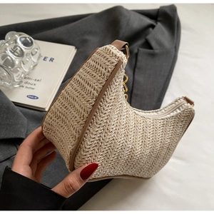 Detail of woven hobo bag showing beige herringbone texture and brown leather trim