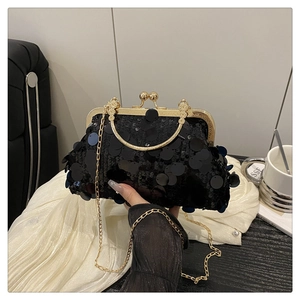 Detail of elegant black sequin evening clutch with gold vintage frame and bead clasp