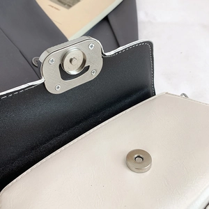 Detail of magnetic silver clasp and lychee pattern leather texture on stylish handbag