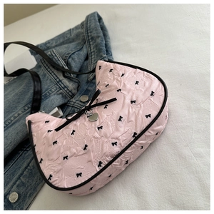 Vista dall'alto della borsa hobo rosa con fiocchi neri, pieghe e ciondolo a cuore