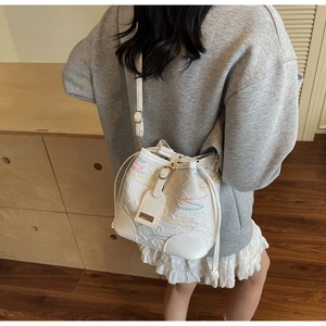 Detailed shot of white bucket bag with colorful wavy stitching and floral embossing