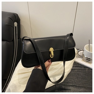 Close-up of black leather baguette bag with a golden oval buckle and shoulder strap