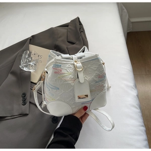Detail view of white bucket bag with colorful wavy stitching and gold metal buckle