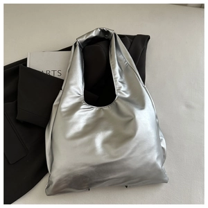Close-up of metallic silver tote bag with mirror finish on a minimalist background