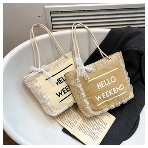 Detail of woven tote bags with lace trim and Hello Weekend slogan on canvas