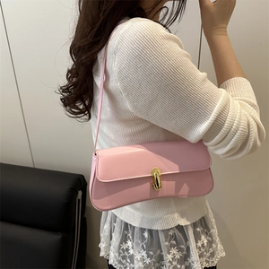 Chic pink shoulder bag with gold oval twist lock and smooth leather finish in a side view