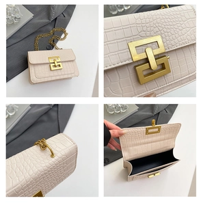 Detalle de bolso crema con textura de cocodrilo, hebilla dorada y correa de cadena