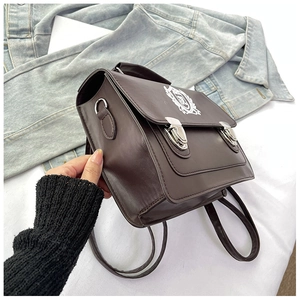 Detail view of brown vintage satchel bag with silver metal buckles and shield badge