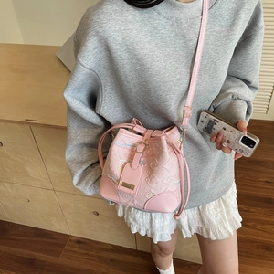 Stylish pink bucket bag with embossed monogram pattern and adjustable shoulder strap