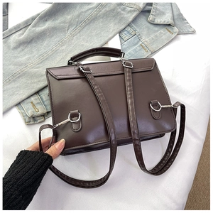 Detail of dark brown retro JK uniform bag showing metal buckles and PU leather straps