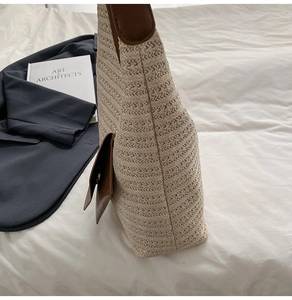 Detail of hand-woven straw tote bag featuring brown leather trim and side pocket