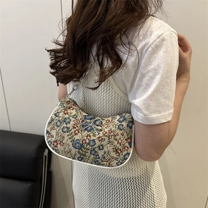 Floral jacquard crescent shoulder bag with metallic bow and chain strap on model