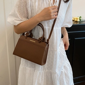 Brown crocodile embossed tote bag with top handles and adjustable shoulder strap