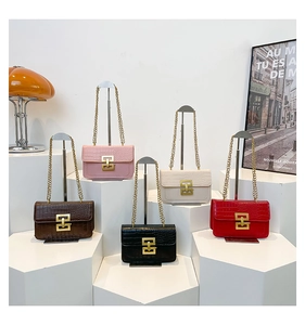 Detalle de cinco bolsos con relieve de cocodrilo, cierres dorados y correas de cadena