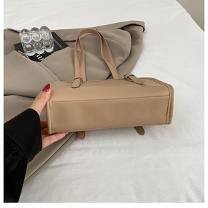 Detail of minimalist khaki tote bag featuring gold lettering and adjustable straps