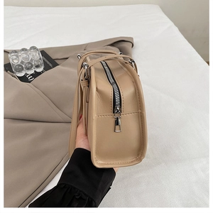 Detailed macro view of the silver metal zipper and smooth leather texture of the tote bag