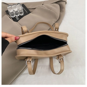 Detail view of khaki tote bag interior showing black lining and silver zip closure