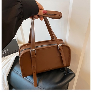 Detailed view of caramel leather handbag with FASHION & BAG logo and silver hardware