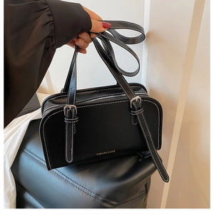 Detail of Boston handbag featuring white contrast stitching and gold fashion lettering