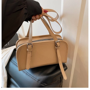 Detail of beige PU tote bag featuring adjustable strap and fashion text decoration
